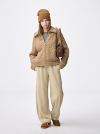 Model wearing beige barrel-leg sweat pants styled with a knit sweater and beanie.