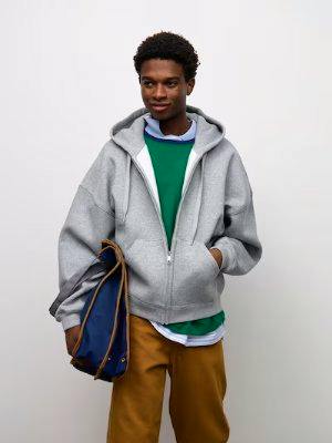 Male model wearing a gray oversized full-zip hooded sweatshirt.