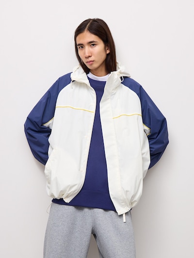 Front view of a model wearing the bicolor heavy-weight cocoon parka (men's jacket) with a white body and navy sleeves.