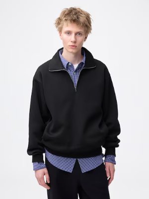 Male model wearing the heavyweight half-zip pullover (black) over a collared shirt.