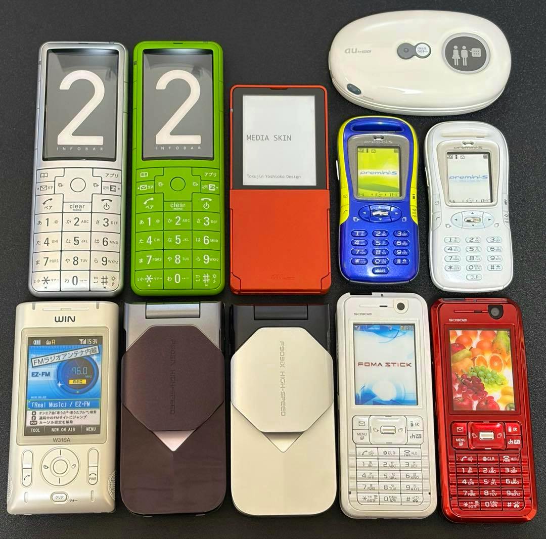 Front view of eleven retro au/docomo Japanese feature phone mockups arranged in a grid on a dark background.
