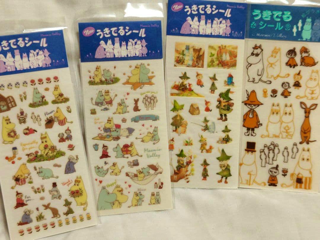 Four packaged Moomin sticker sheets displayed side by side, each showing various Moomin character stickers and blue header labels.