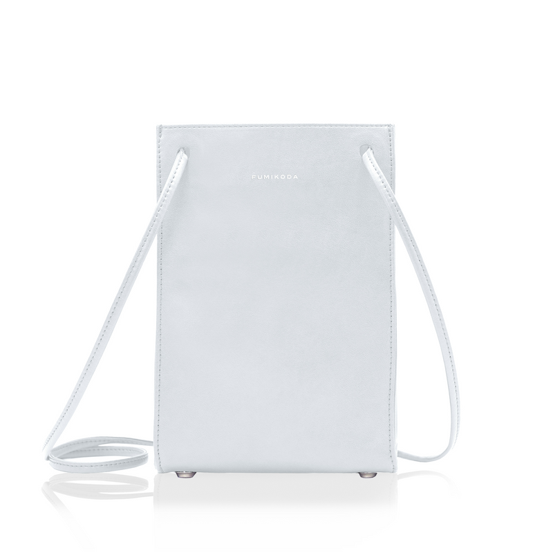 Front view of the HELEN cow leather crossbody bag in a light color with a long strap and small metal feet on a white background.