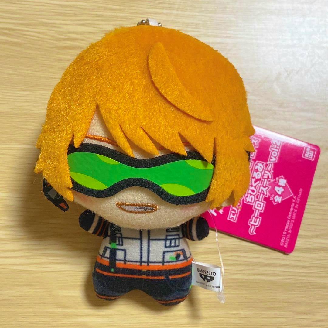 Front view of the chibi Billy plush from Erios Rising Heroes with orange felt hair, a green visor, printed outfit, and a pink product tag attached.
