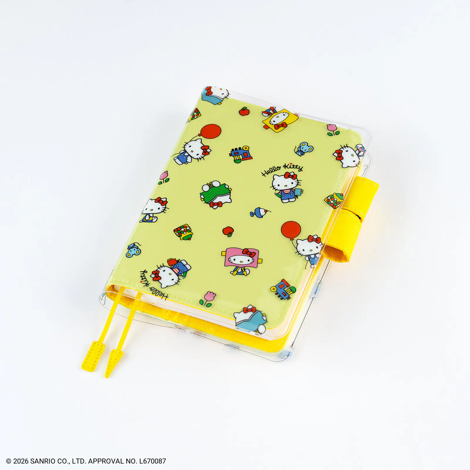A clear plastic A6 book cover with a yellow Hello Kitty–patterned insert and a yellow pen loop.