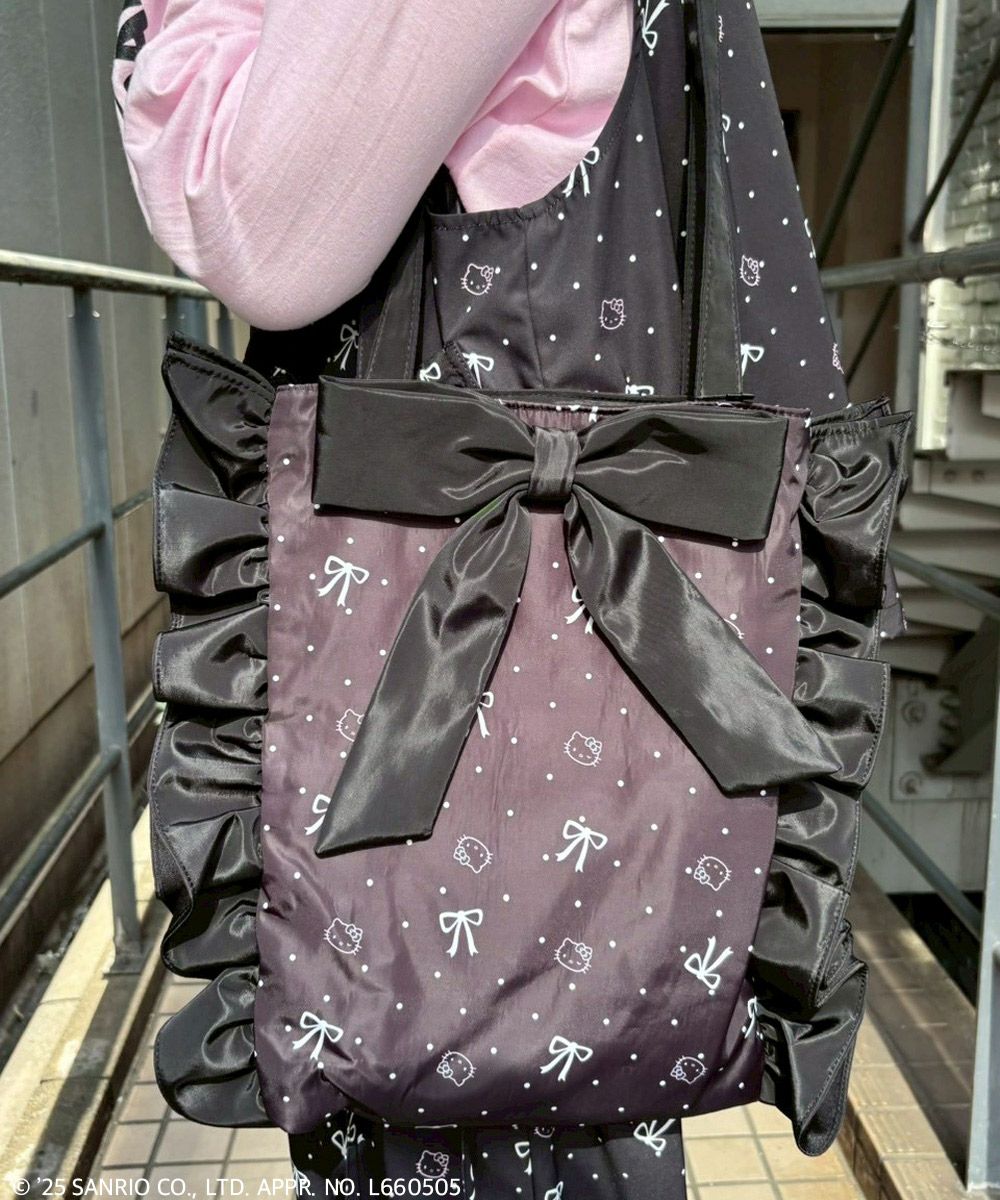 Close-up of the Hello Kitty Ribbon & Dot tote bag with a large satin bow and ruffled sides worn over a person's shoulder.
