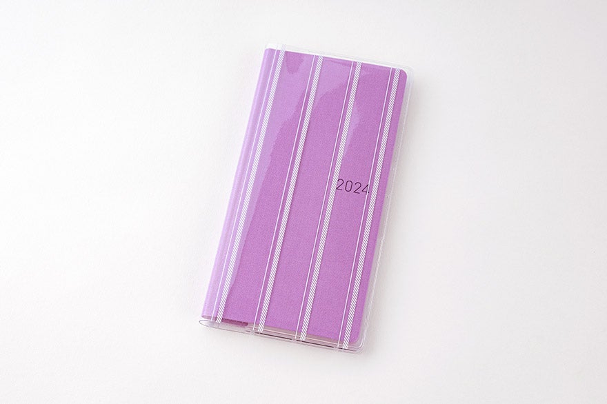 A purple-striped clear cover fitted over a Weeks diary showing "2024" on the front.