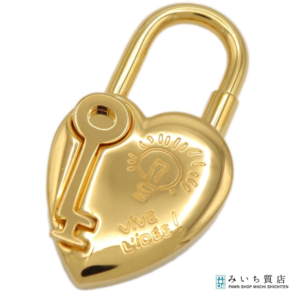 Gold heart-shaped HERMES padlock charm with an attached key and an engraved lightbulb motif.