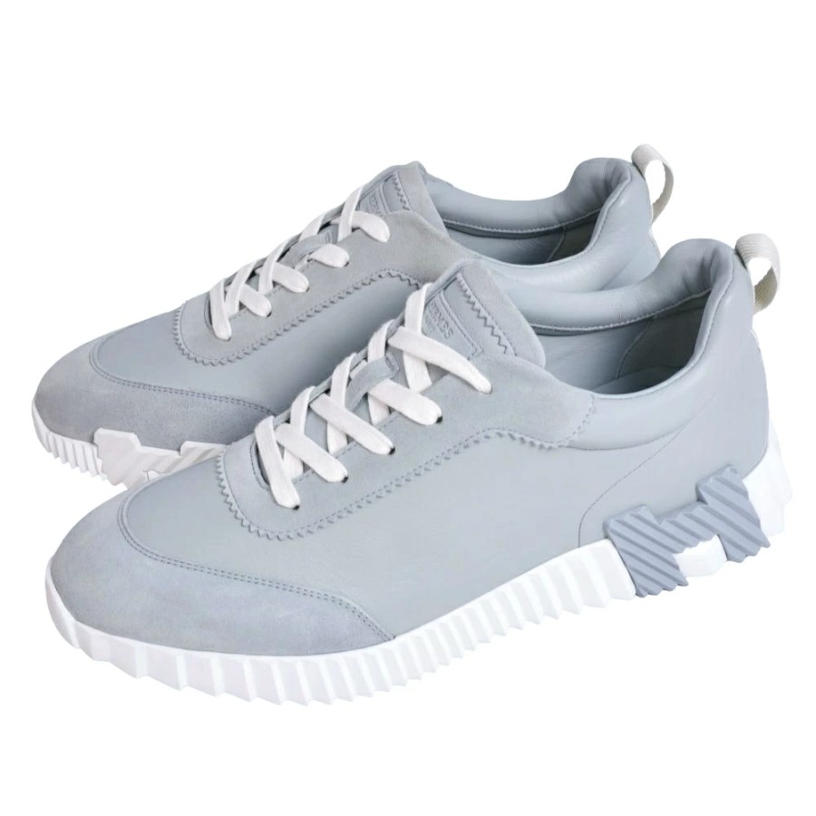 Two light blue low-cut sneakers with white laces and white textured soles shown from an angled top-side view.