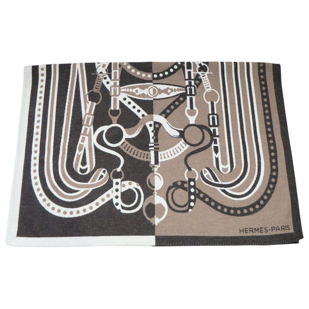 Brown Merino wool/cashmere blanket with a symmetrical equestrian bit pattern and HERMES-PARIS logo laid flat.