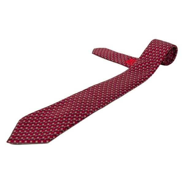 Burgundy and red Hermès men's silk necktie with a repeating geometric pattern laid flat on a white background.