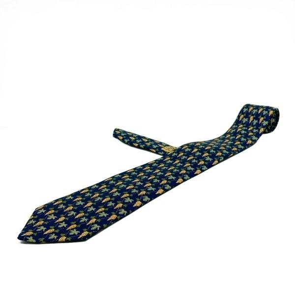 Navy silk men's necktie with dark yellow and black patterned design laid flat on a white background.