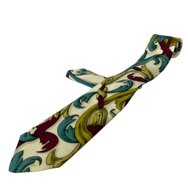 Silk men's necktie in white with dark green and multicolor patterned design displayed.