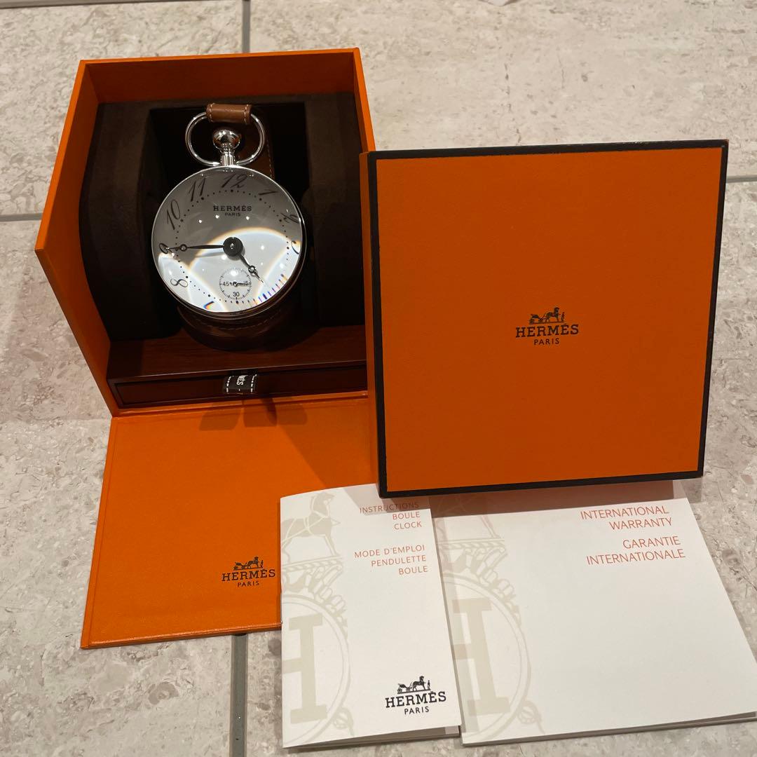 Hermès silver metal and leather desk clock displayed inside its orange box with accompanying paperwork.