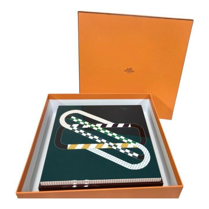 Hermes orange outer box with lid open revealing a patterned storage box placed inside.