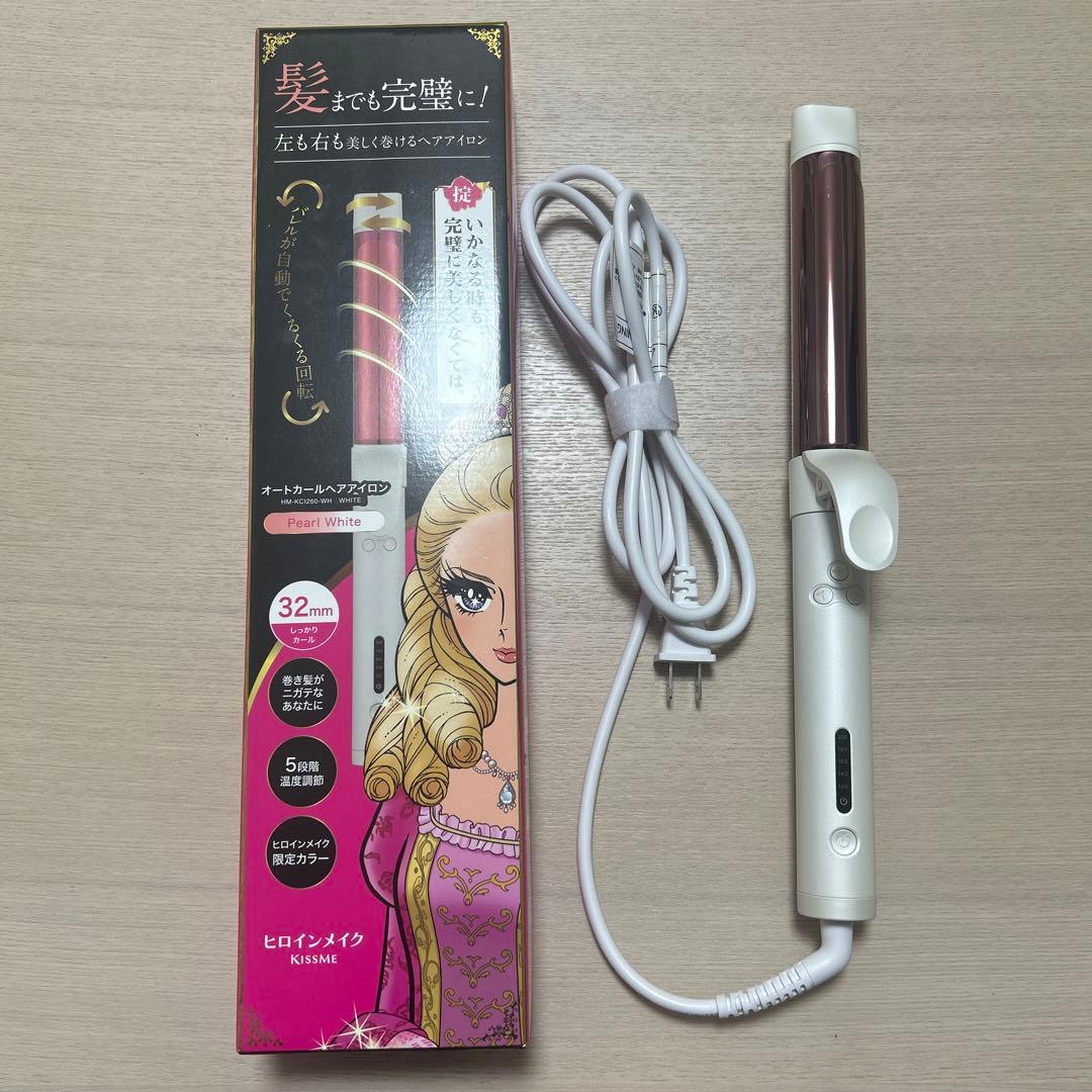 A 32mm auto-curl hair iron with its coiled power cord displayed next to its illustrated retail box on a light wood surface.