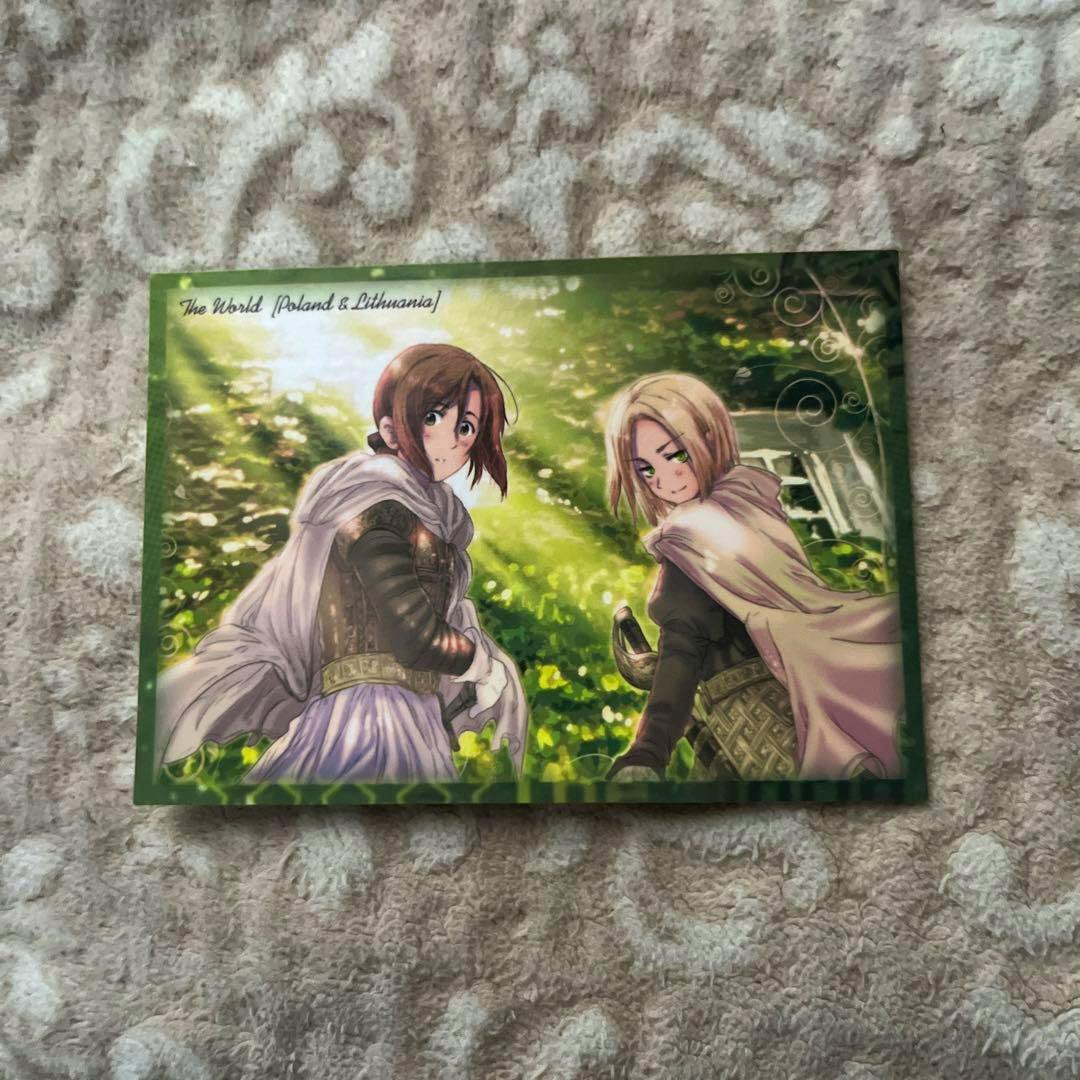 A Hetalia photocard featuring Poland and Lithuania characters with a green forest-like background resting on a textured blanket.