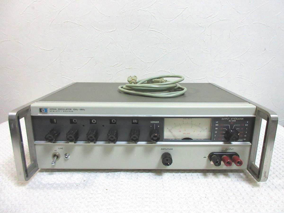 Front view of the Hewlett Packard 4204A oscillator showing the front-panel controls, meter, and output terminals with a coiled power cord on top.