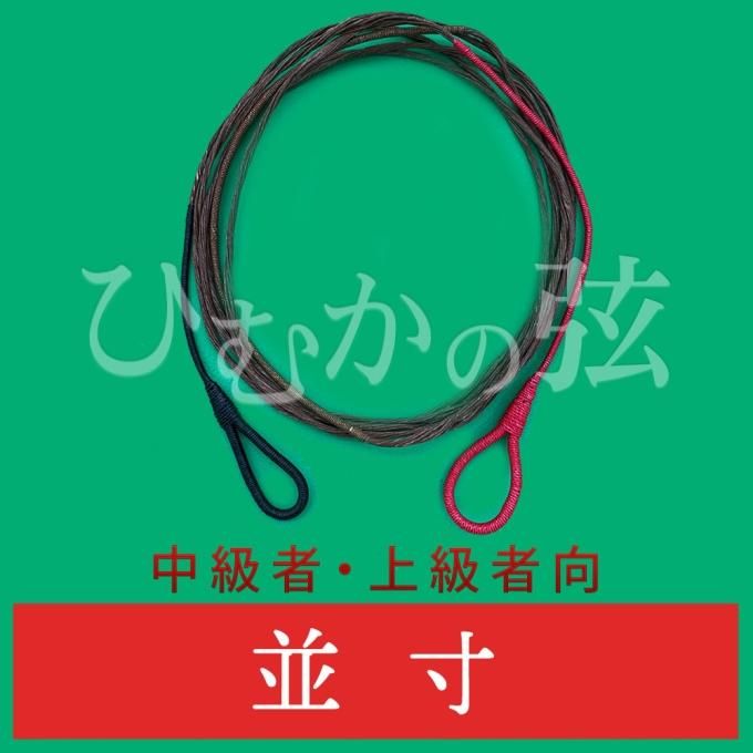 Coiled ひむかの弦 Majesty777 archery string with red and black loop ends on a green background.