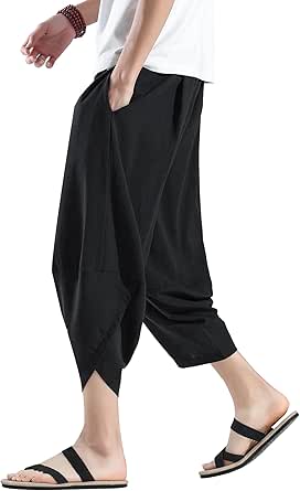 Side view of a model wearing black 3/4-length sarouel (Aladdin-style) men's pants with pockets.