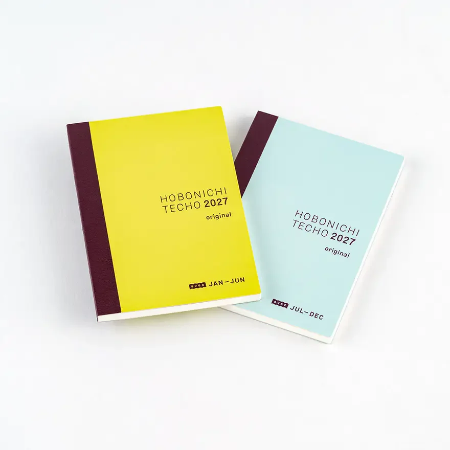 Two Hobonichi Techo 2027 A6 daily books, one yellow (Jan–Jun) and one light blue (Jul–Dec), shown on a white background.