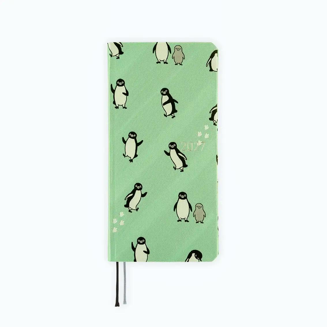 Green planner with a canvas Suica penguin pattern on the cover and two ribbon bookmarks visible.