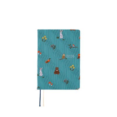 A teal A6-sized daily notebook with forest animal illustrations and “2026” on the cover against a white background.