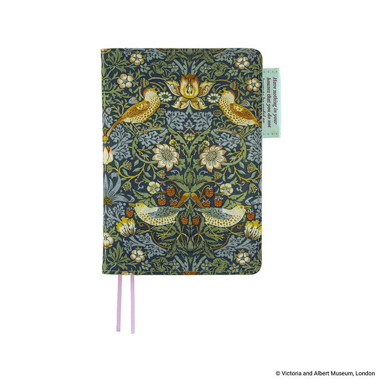 Closed A6 cotton book cover (V&A Strawberry Thief) showing the floral-and-bird patterned front, a small green fabric tag at the edge, and two pink ribbon bookmarks.
