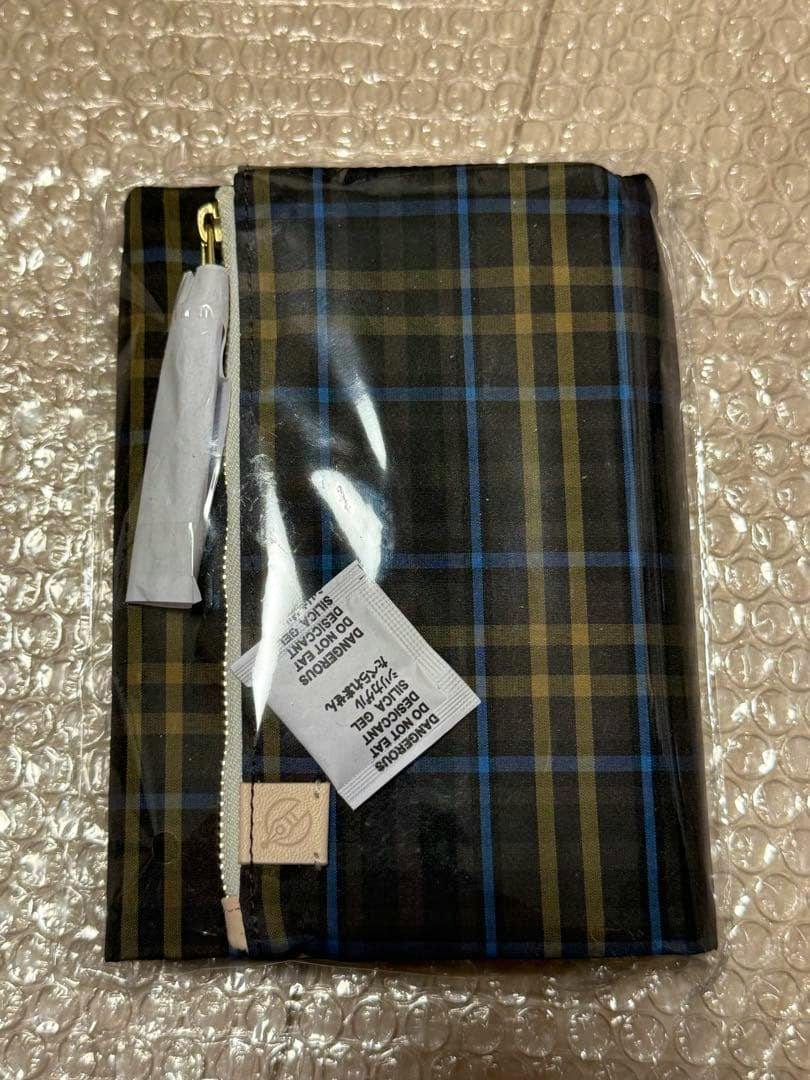 Hobonichi Techo cover (Original A6) in a bitter check pattern, shown sealed in plastic with tags on a bubble-wrap surface.