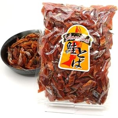 Packaged bag of salmon jerky pieces displayed with a small bowl of jerky behind it.