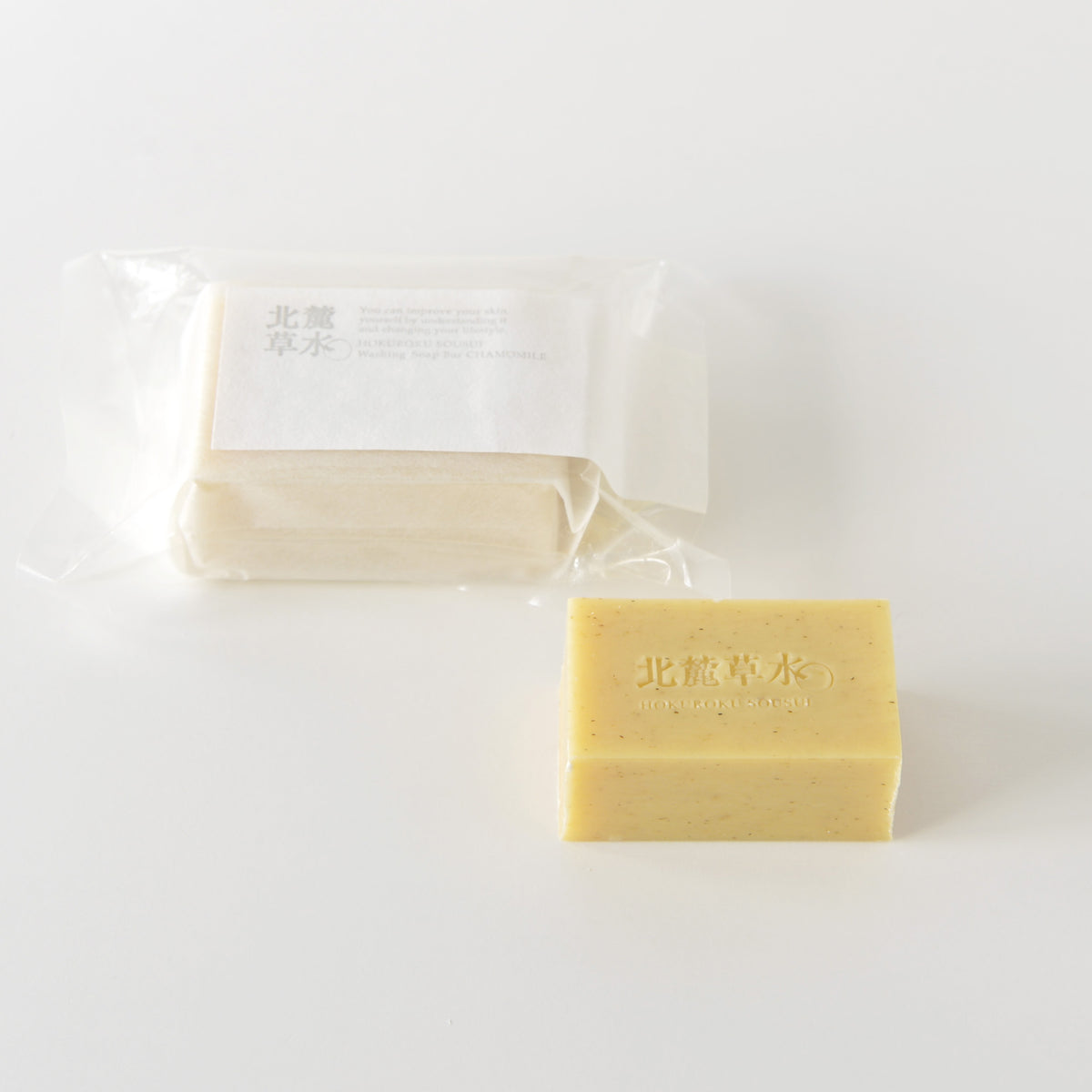 A wrapped and an unwrapped washing soap bar labeled カミツレ (seasonal) displayed on a white background.