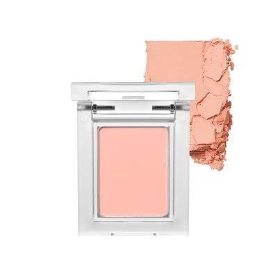 Clear square compact of peach-colored blush with a swatch of crushed powder beside it.