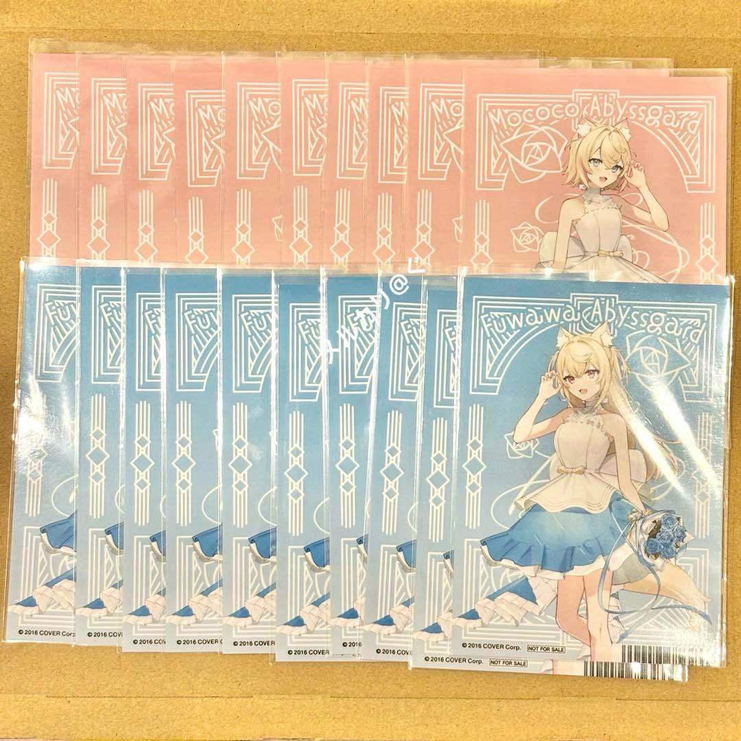 Multiple Hololive Animate 7th anniversary promotional photocards featuring a blonde, cat-eared anime character with blue-front and pink-back designs arranged on cardboard.
