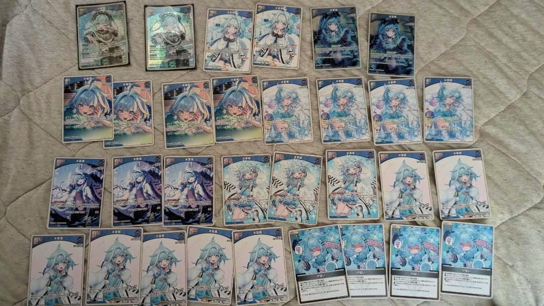 Multiple photocards from the product 'ホロライブカード　バウンサーバウンド　水宮枢セット' arranged on a quilted fabric background.