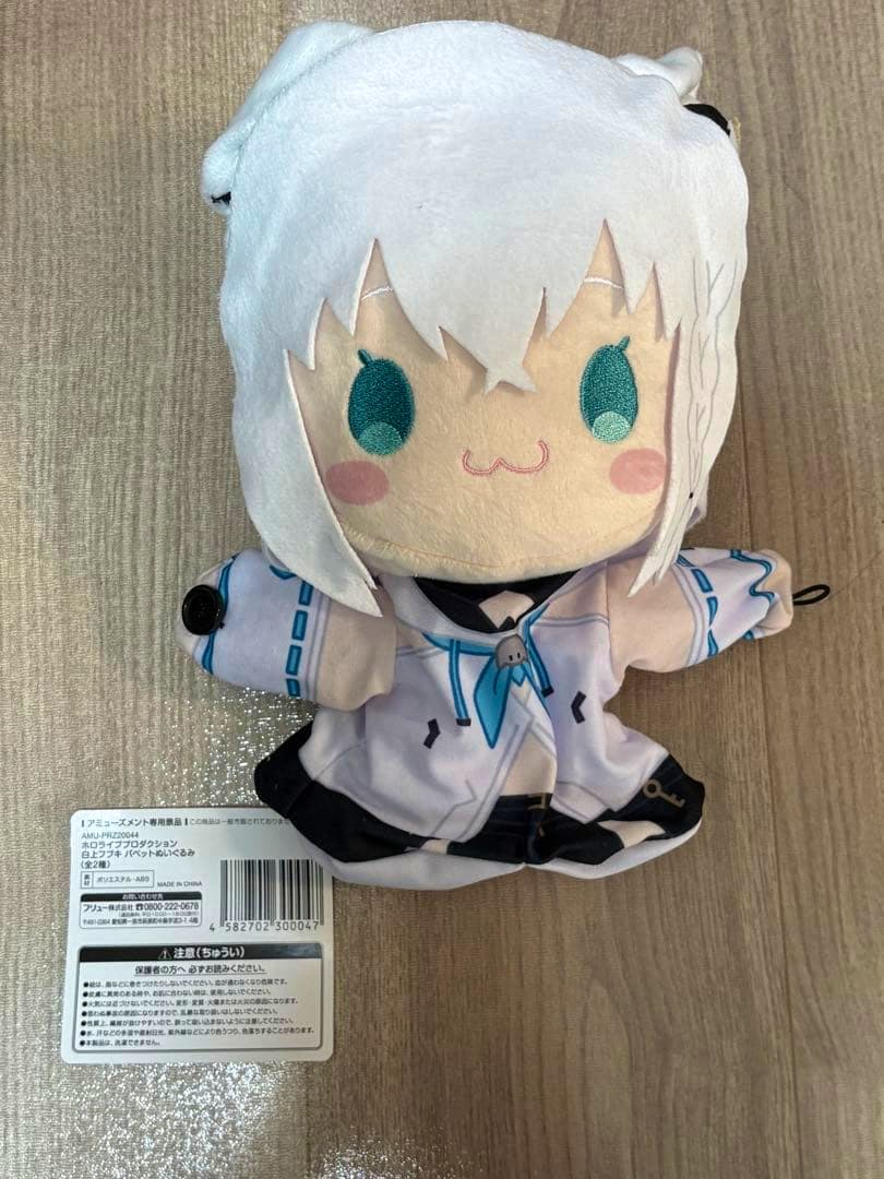 Front view of the Shirakami Fubuki puppet plush showing its face, white hair, and white-and-blue outfit with the product tag visible.
