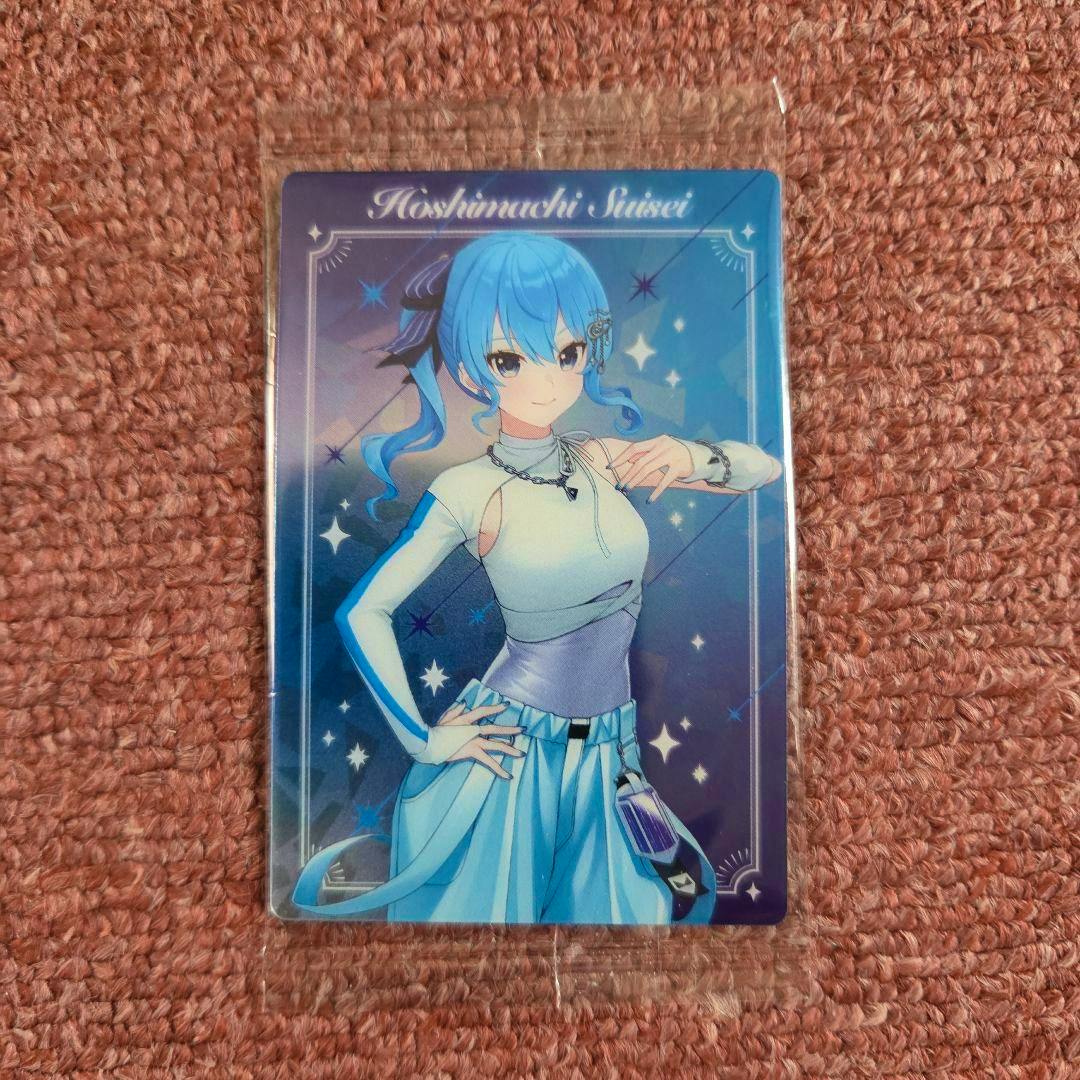 Front of the ホロライブ 星街すいせい ウエハース photocard showing an illustrated Hoshimachi Suisei in a plastic sleeve on a pink carpet.