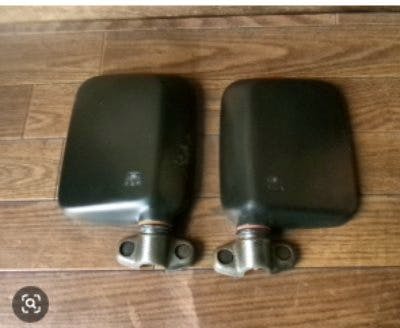 A pair of car side mirror assemblies (left and right) shown side by side on a wooden floor.