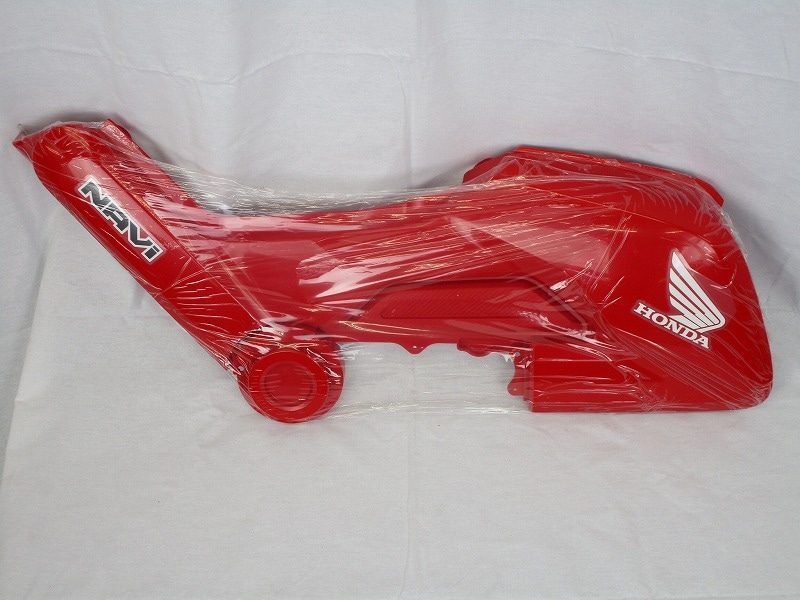 Red Honda Navi110 right side cover wrapped in protective plastic showing NAVI and Honda wing logos on a white background.