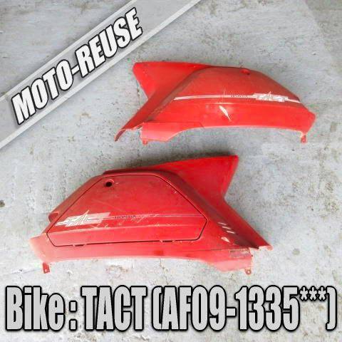 Two red motorbike rear cowl panels for a Tact (AF09) laid on a concrete floor.
