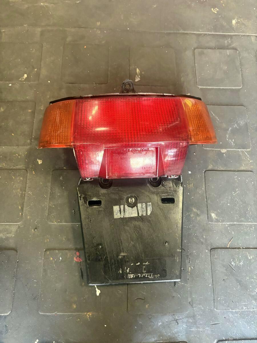 Front view of the AF09 Tact tail lamp assembly with red and amber lenses mounted to a black license-plate bracket.