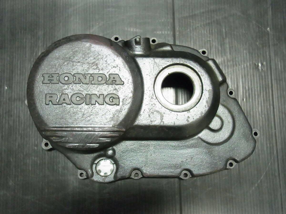 Top-down photo of a Honda Racing motorbike engine cover (VFR750R/RC30) placed on a black surface.