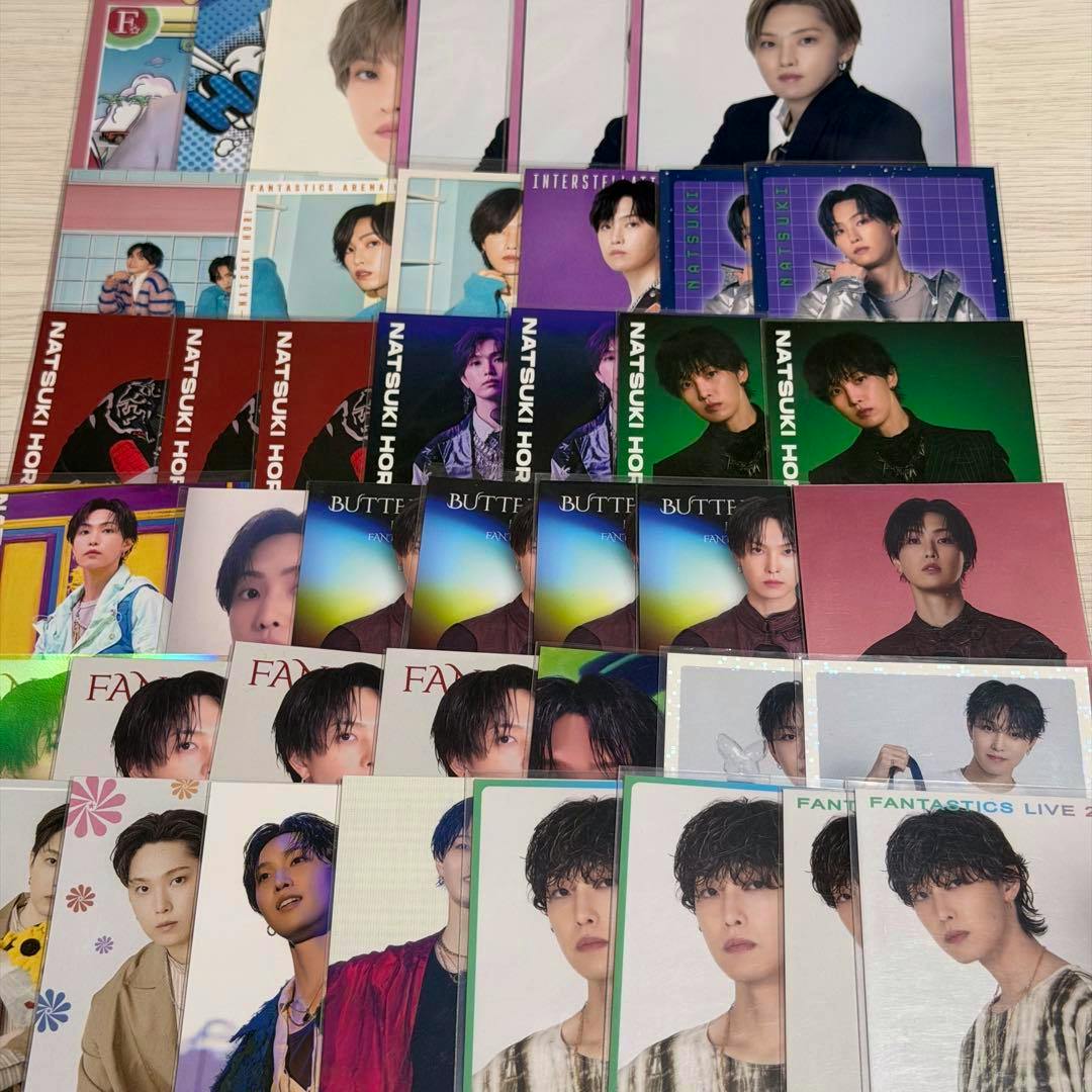 Several photocards featuring a male pop artist arranged in rows on a tabletop.