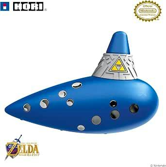 Blue ocarina toy with multiple finger holes and a silver decorative top bearing a Triforce emblem, shown with Hori and Nintendo license logos.