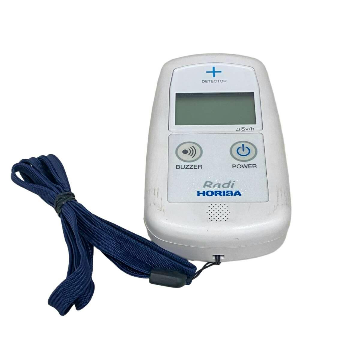 Front view of the HORIBA Radi PA-1000 environmental radiation monitor showing the display, buzzer and power buttons with an attached blue lanyard.
