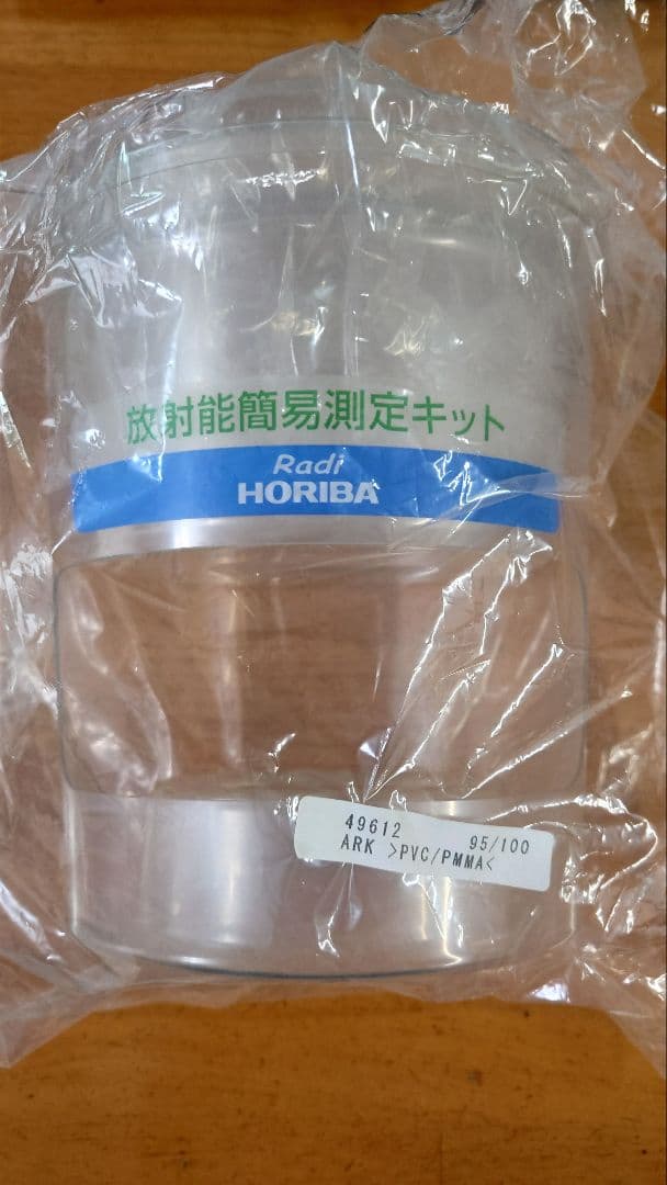 Sealed clear plastic container from a HORIBA Radi radiation measurement kit inside plastic wrapping.