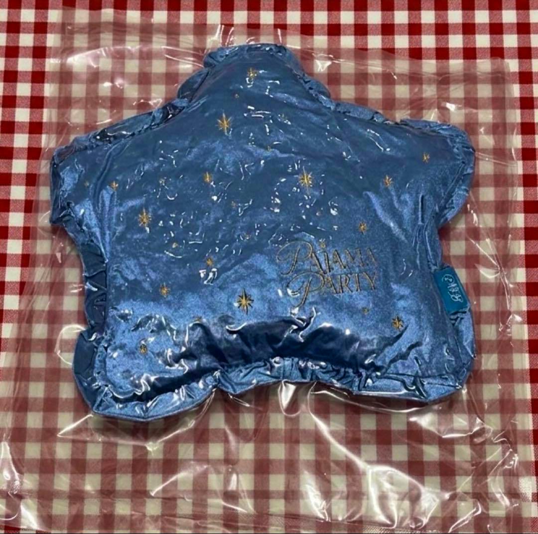 Blue star-shaped cushion from the 'ぱじゃまぱーてぃー Vol.1' fan meeting set, with gold star motifs and 'Pajama Party' embroidery, shown in plastic packaging on a red gingham surface.