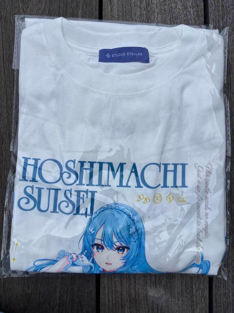Folded white Hoshimachi Suisei T-shirt in plastic packaging showing a blue-haired character illustration and large "HOSHIMACHI SUISEI" text.