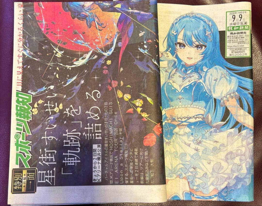 Open newspaper spread showing an illustration of Hoshimachi Suisei on the right and Japanese text with the Sports Hochi logo on the left.