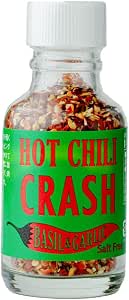 Glass bottle of Hot Chili Crush Basil & Garlic seasoning filled with red chili flakes and a green label.
