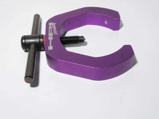 Purple metal flywheel puller with threaded bolt and T-handle on a white background.
